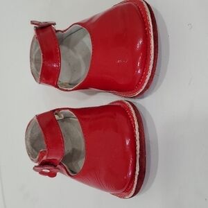 Red leather Mary Jane's with flower details and Velcro closure